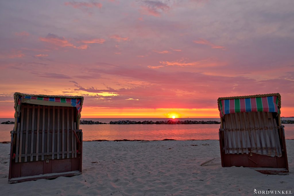 zwei strandkörbe im licht der untergehenden sonne an der ostsee