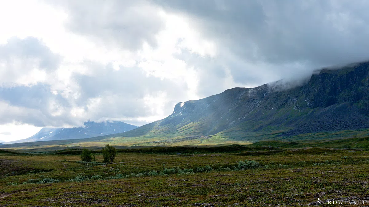 sonne bricht durch wolkendecke im hochgebirge des sarek nationalpark und sorgt für hell-dunkel-kontraste