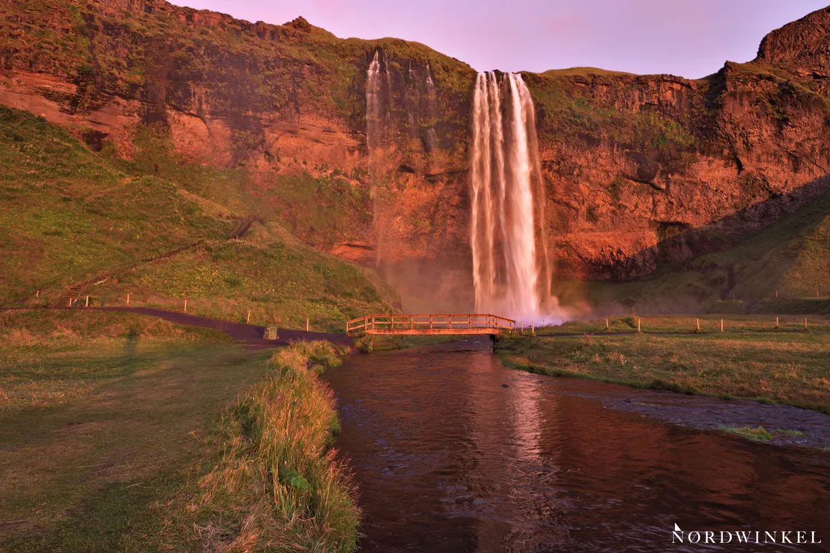 wasserfall im roten sonnenuntergangslicht in grüner umgebung als beispiel rot-grü+-kontraste