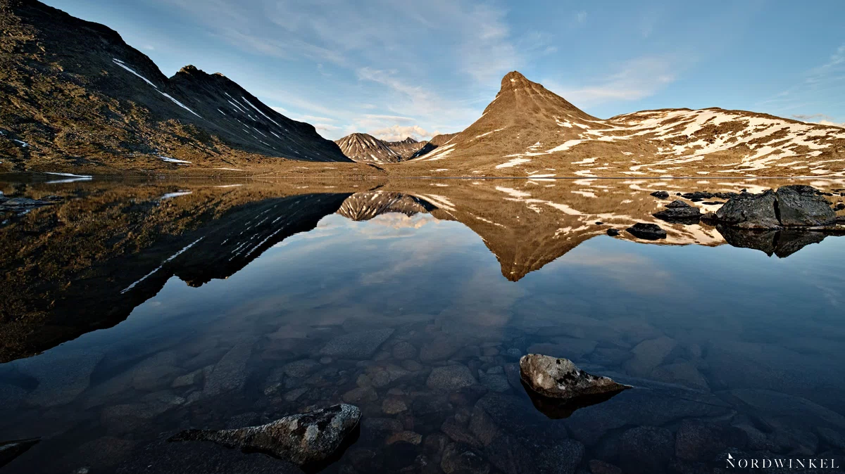 gebirgssee mit berggipfel im hintergrund und als spiegelbild