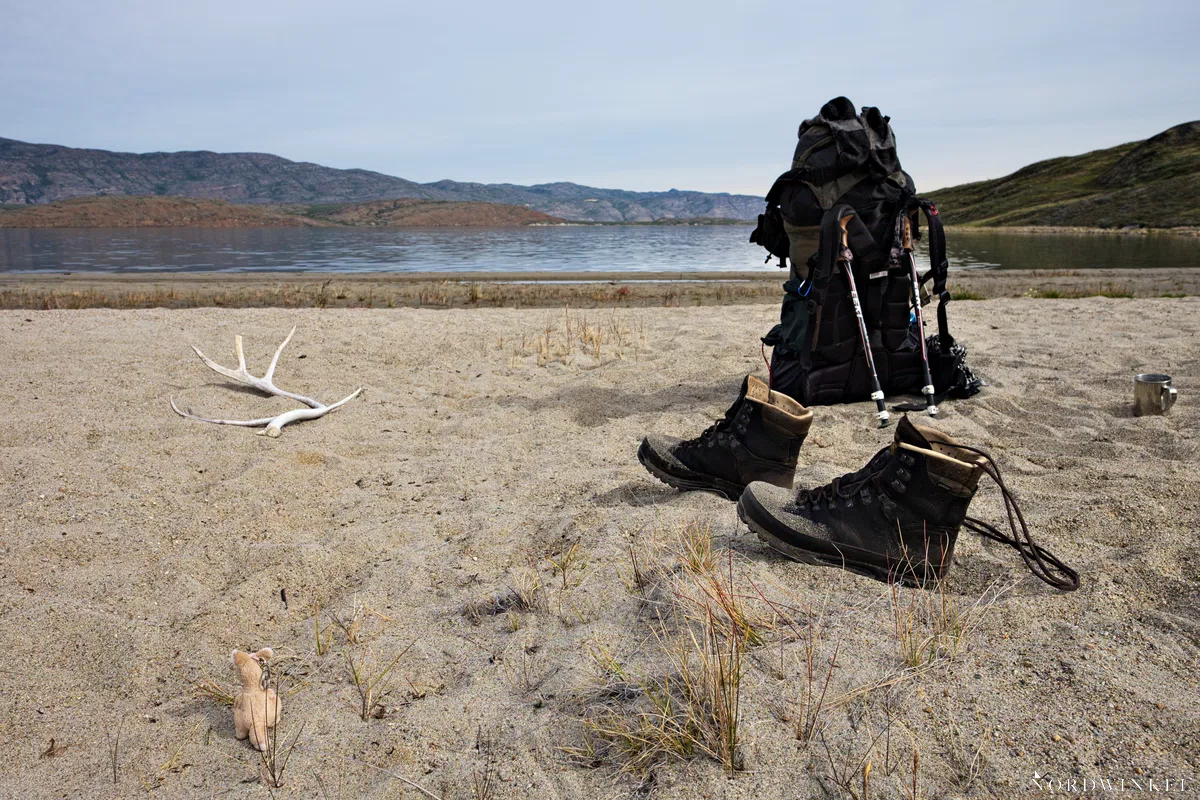 Trekking-Ausrüstung an einem Strand eines Sees