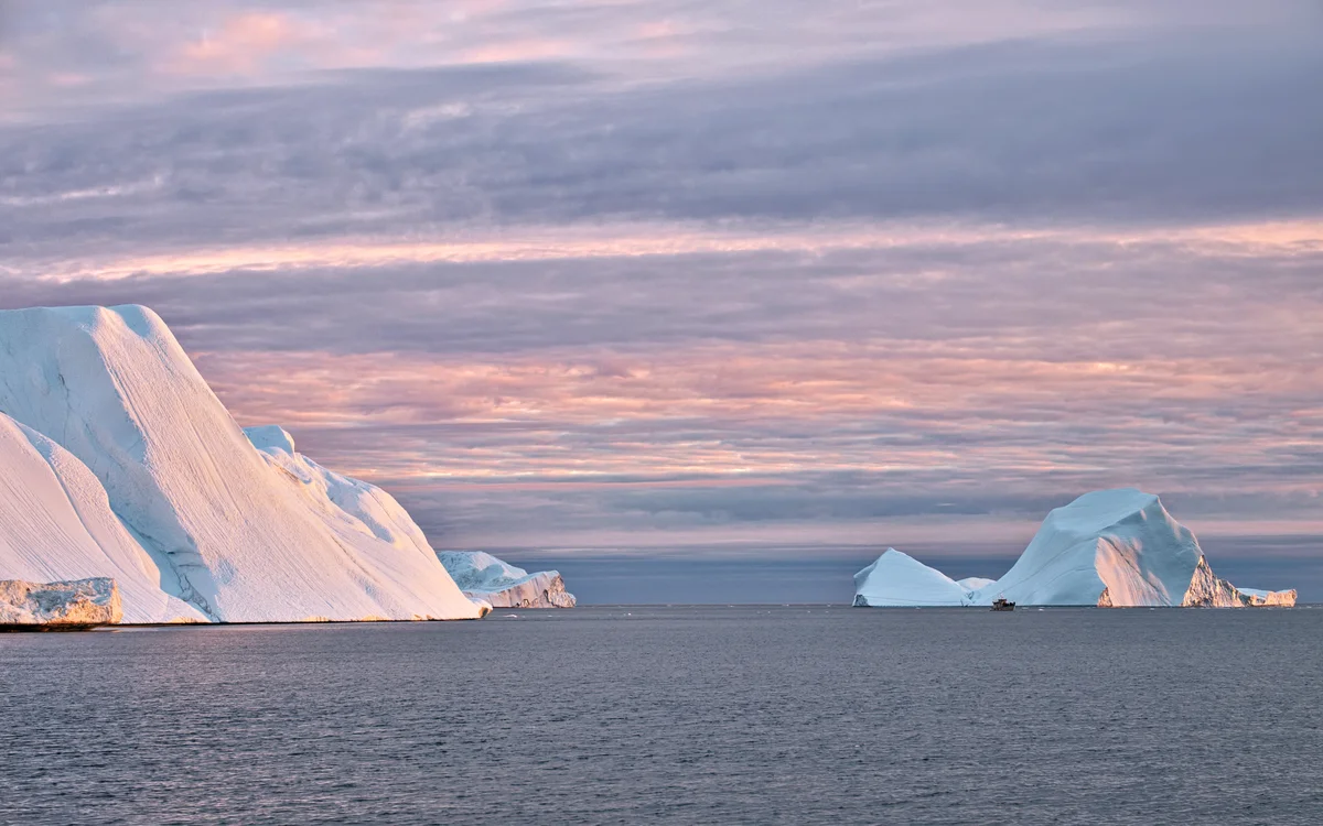 eisberger im rötlichen sonnenuntergangslicht